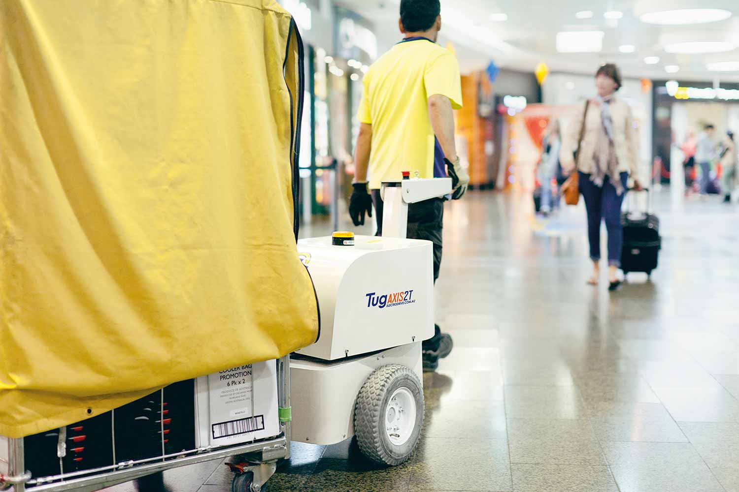 Electrodrive's Tug Axis towing a large trolley through an airport